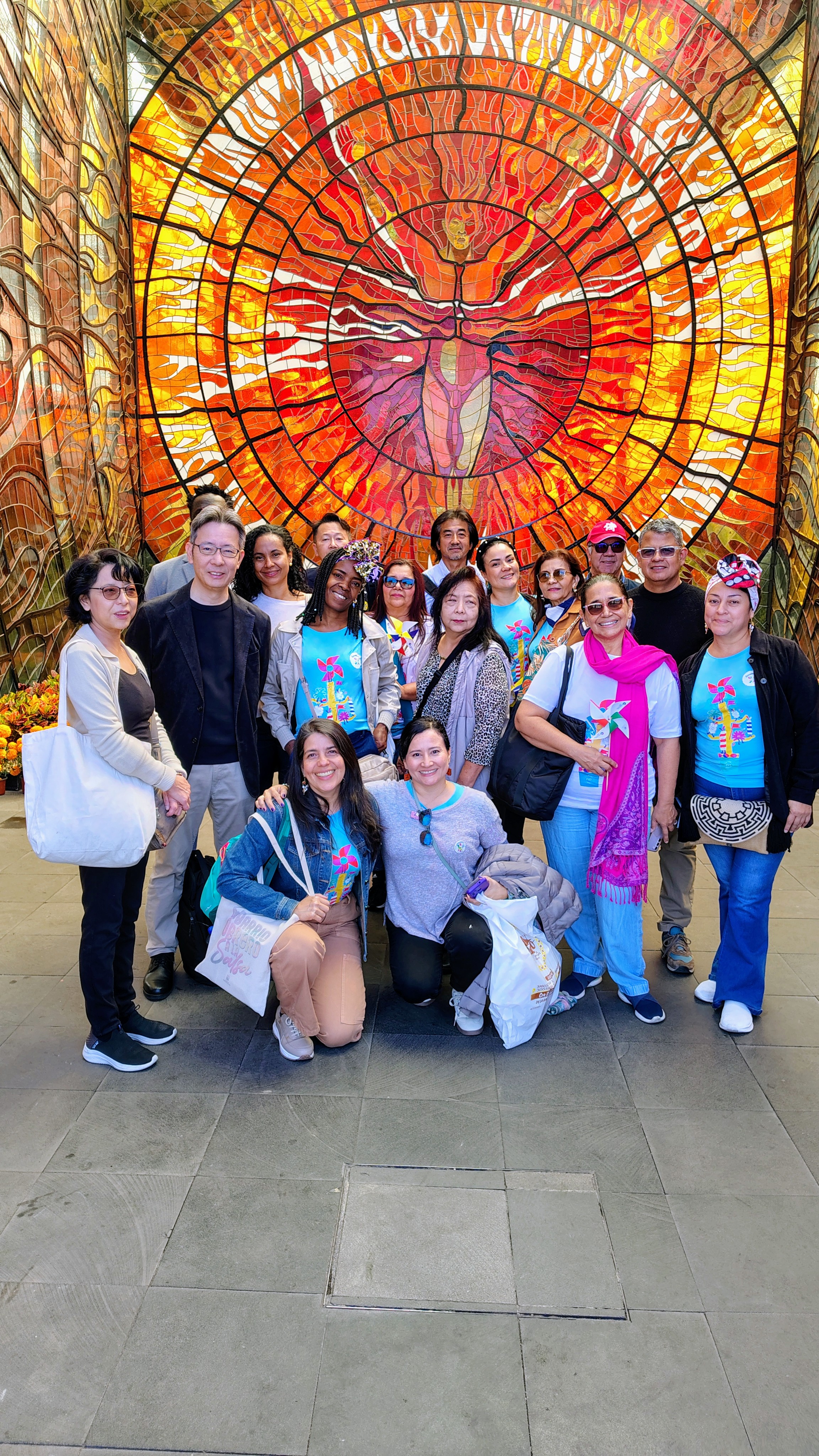 Delegaciones de Cali, Toluca y Japón reunidas en México frente a un vitral